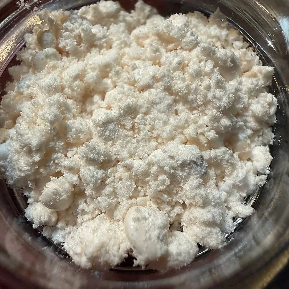 CBG isolate powder inside an open glass concentrate jar